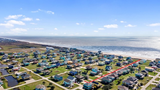 birds eye view of property featuring a beach view and a water view