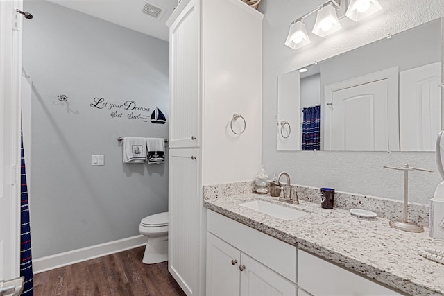 bathroom featuring hardwood / wood-style flooring, vanity, and toilet