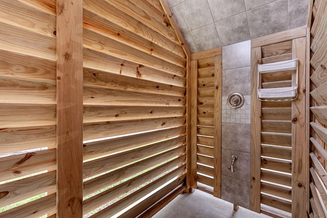 wine area with vaulted ceiling and wooden walls