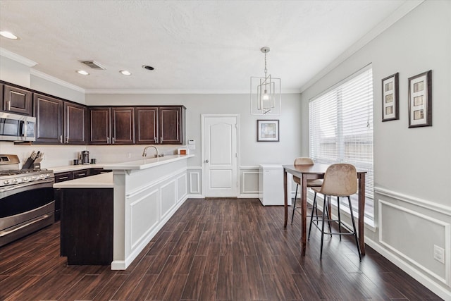 kitchen featuring dark brown cabinets, dark hardwood / wood-style flooring, stainless steel appliances, and hanging light fixtures