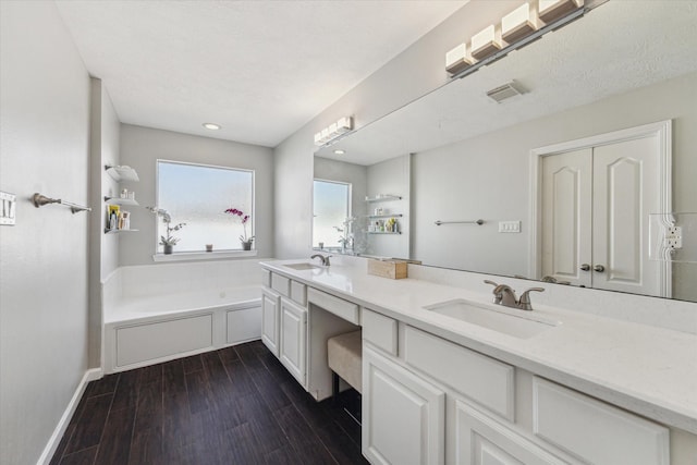 bathroom featuring hardwood / wood-style flooring, vanity, and a bathtub