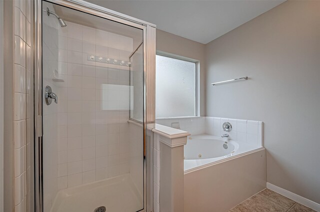 bathroom with a garden tub, tile patterned flooring, baseboards, and a stall shower