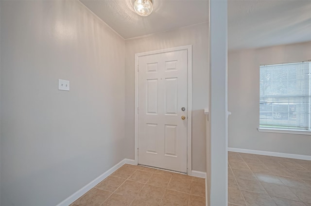 doorway to outside featuring light tile patterned floors and baseboards