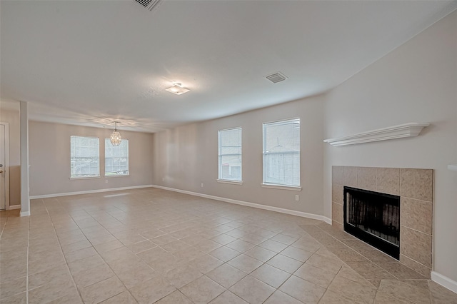 unfurnished living room with light tile patterned flooring, a fireplace, and baseboards