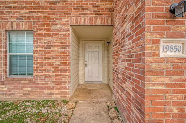 property entrance featuring brick siding