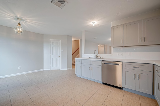 kitchen featuring dishwasher, light countertops, a sink, and gray cabinets