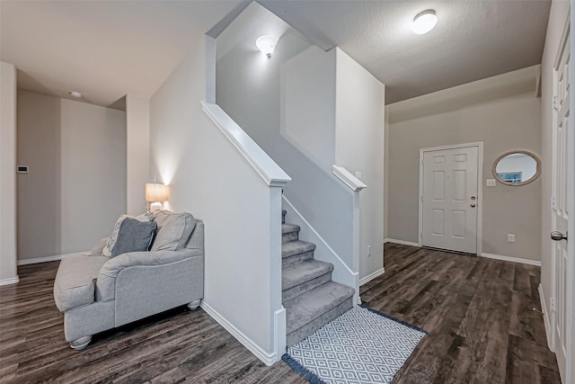 entrance foyer with dark hardwood / wood-style flooring and a textured ceiling