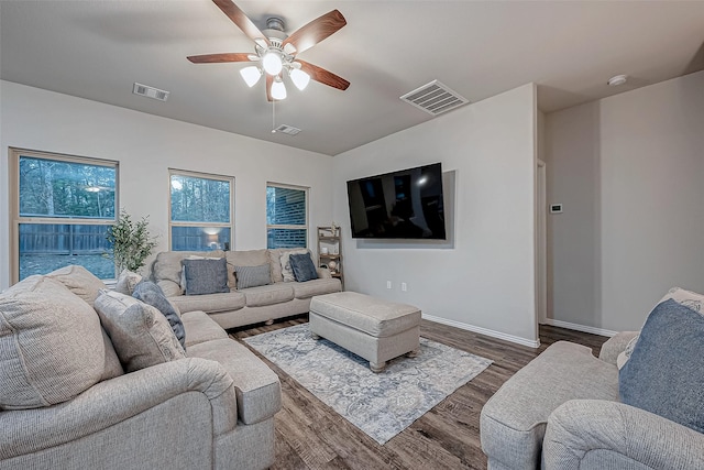 living room featuring ceiling fan and dark wood-type flooring