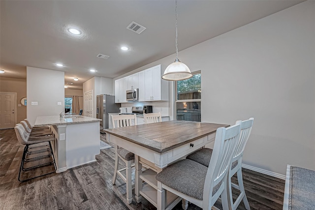 dining area with dark wood-type flooring and sink