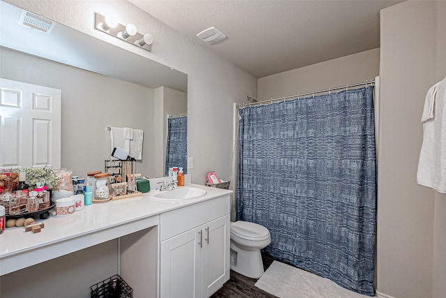 bathroom featuring toilet, hardwood / wood-style flooring, and vanity