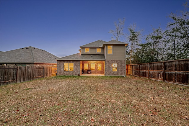 back of property with a lawn and a patio area