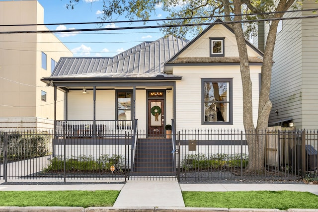 view of front of house with covered porch, metal roof, a fenced front yard, and a gate