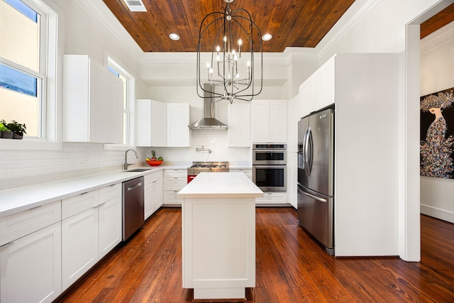 kitchen with white cabinets, a kitchen island, appliances with stainless steel finishes, hanging light fixtures, and light countertops