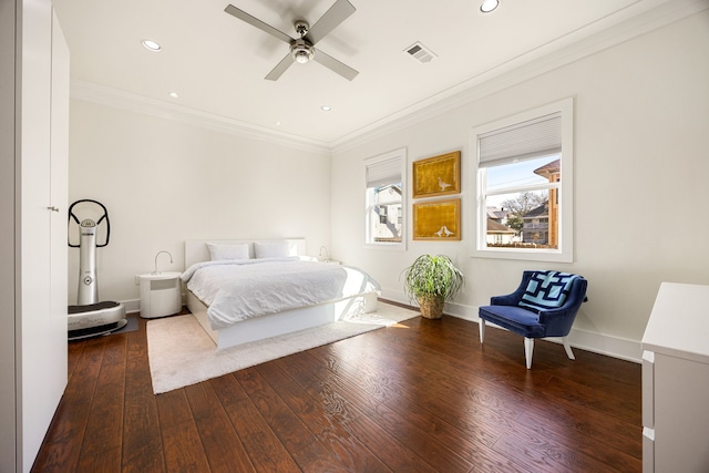 bedroom with baseboards, dark wood finished floors, visible vents, and crown molding