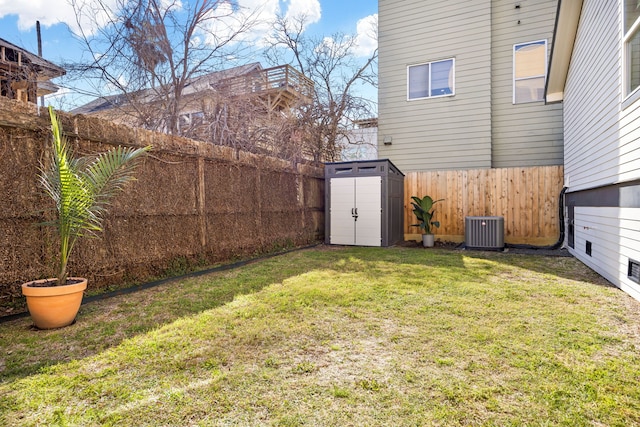 view of yard with central air condition unit, a fenced backyard, an outdoor structure, and a shed