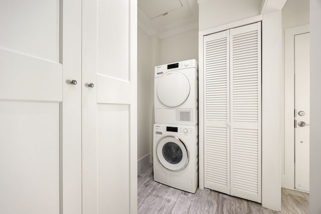 laundry area with light wood-type flooring, stacked washer / dryer, and laundry area