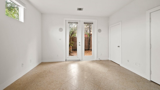 unfurnished room with french doors and plenty of natural light