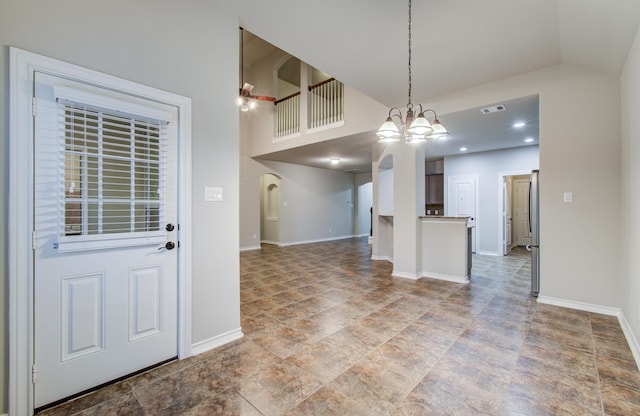 kitchen featuring baseboards, hanging light fixtures, an inviting chandelier, vaulted ceiling, and light countertops