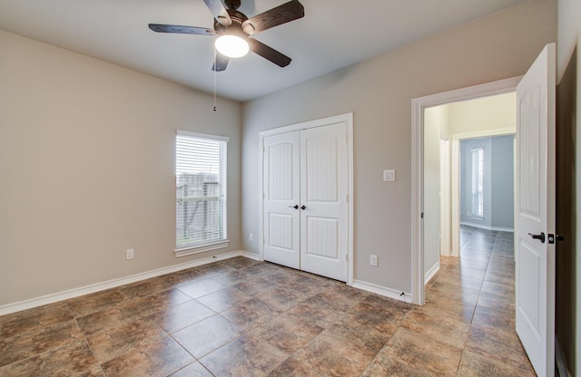 unfurnished bedroom with a closet, ceiling fan, and baseboards