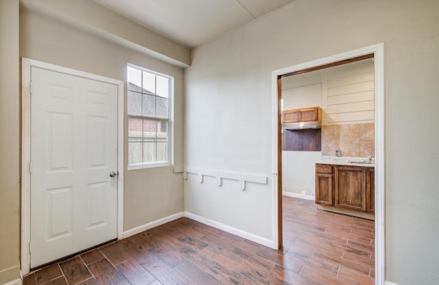 entryway with dark wood-style floors and baseboards