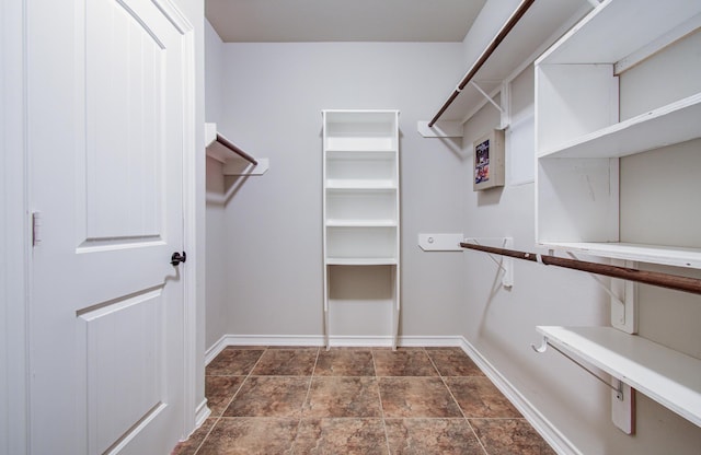 spacious closet featuring stone finish flooring