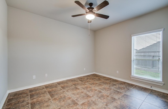 empty room featuring a ceiling fan and baseboards