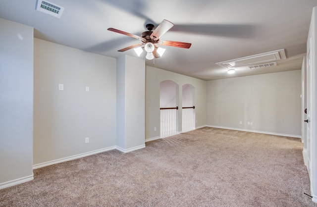 unfurnished room featuring light carpet, ceiling fan, visible vents, and attic access