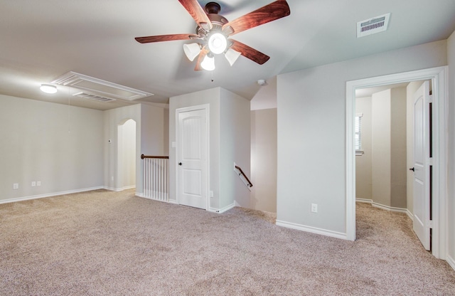 spare room with light carpet, attic access, visible vents, and baseboards