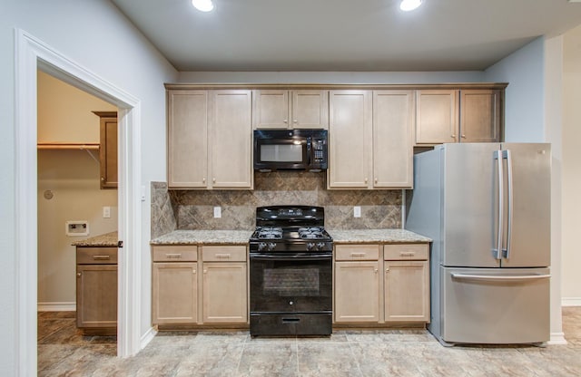 kitchen featuring tasteful backsplash, baseboards, black appliances, and light stone countertops