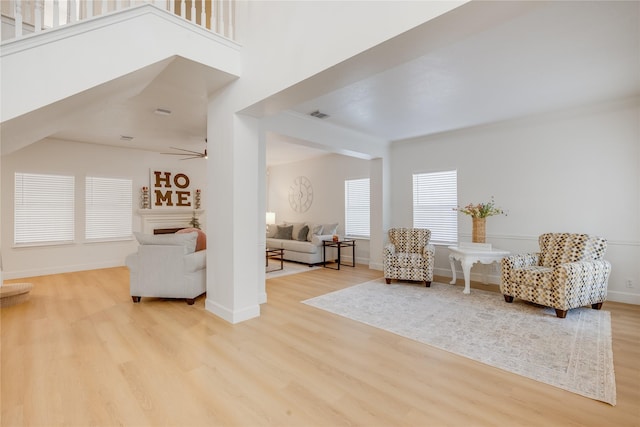 living area with ceiling fan and light hardwood / wood-style floors