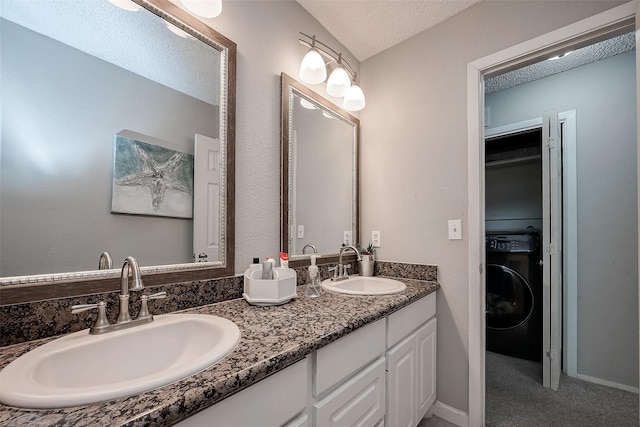 8619 Quail Burg Ln, Houston, TX 77489 - bathroom featuring washer / clothes dryer, double vanity, and a textured ceiling