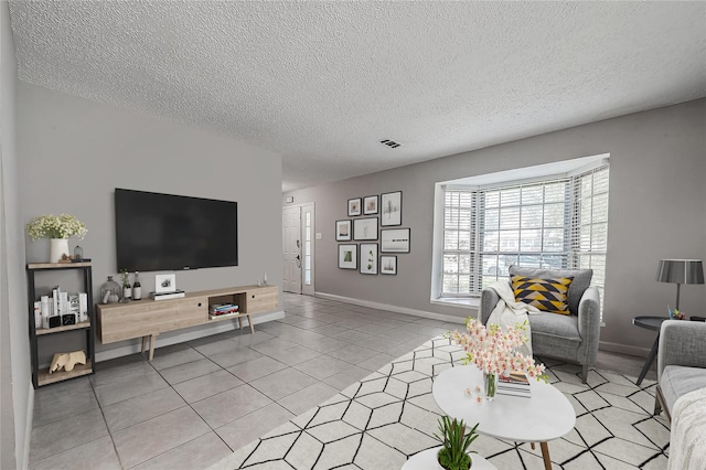 8619 Quail Burg Ln, Houston, TX 77489 - living room featuring a textured ceiling, light tile patterned flooring, and baseboards
