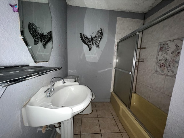 full bathroom featuring sink, tile patterned flooring, toilet, and enclosed tub / shower combo