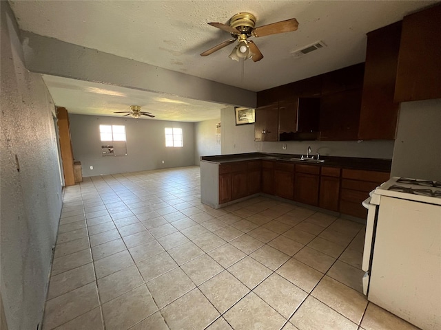 kitchen with ceiling fan, sink, white gas range, and light tile patterned floors