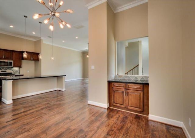 kitchen with ornamental molding, dark hardwood / wood-style flooring, stainless steel appliances, and decorative backsplash