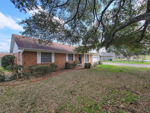 ranch-style house featuring a front yard and a garage