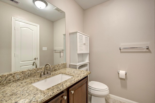 bathroom with baseboards, visible vents, vanity, and toilet