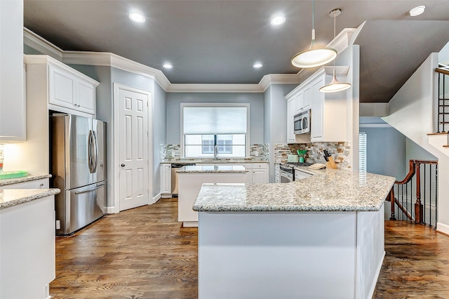 kitchen featuring appliances with stainless steel finishes, light stone counters, white cabinets, decorative light fixtures, and kitchen peninsula