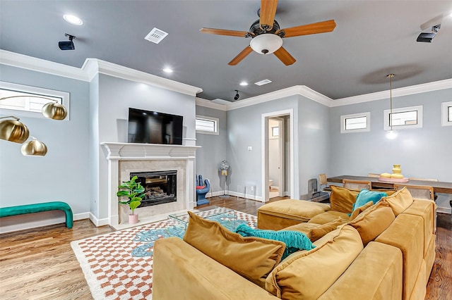 living room featuring a fireplace, ornamental molding, hardwood / wood-style flooring, and plenty of natural light