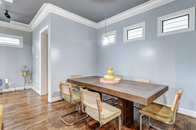 dining area featuring hardwood / wood-style flooring, crown molding, and plenty of natural light