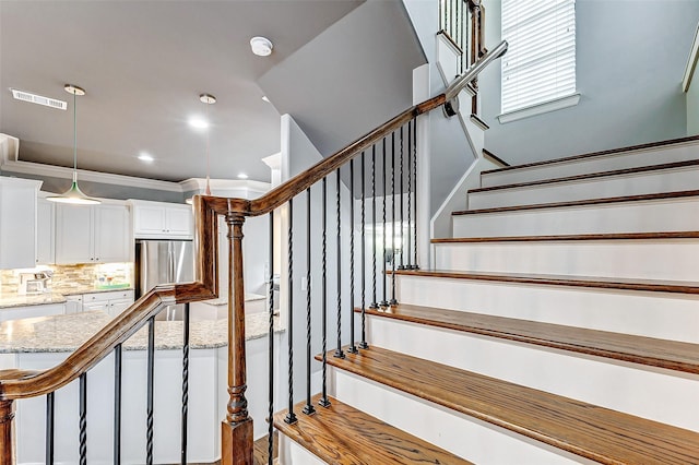 stairway featuring crown molding