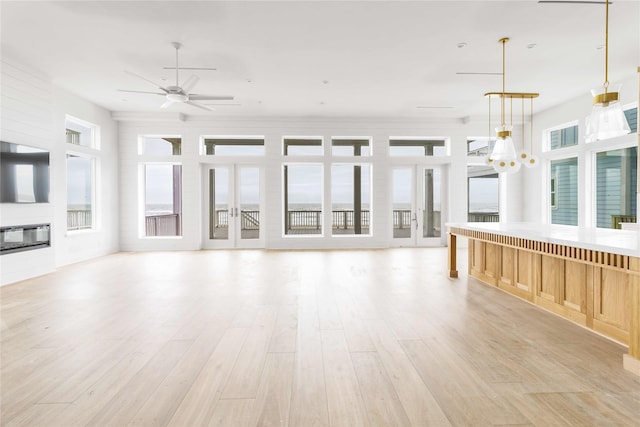 unfurnished living room featuring light wood-type flooring and ceiling fan