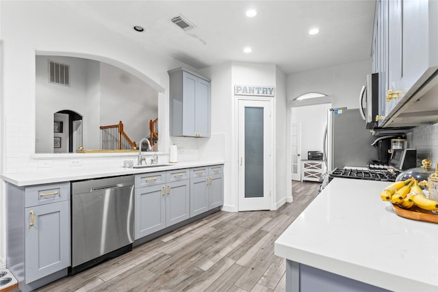 kitchen with stainless steel appliances, light countertops, visible vents, backsplash, and gray cabinetry