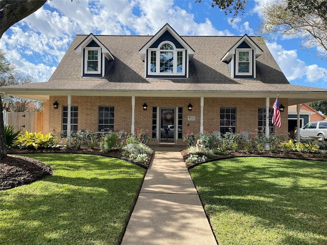 view of front facade featuring brick siding, a front lawn, and roof with shingles