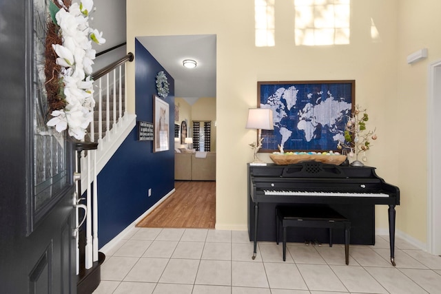 entryway featuring tile patterned floors, stairs, and baseboards