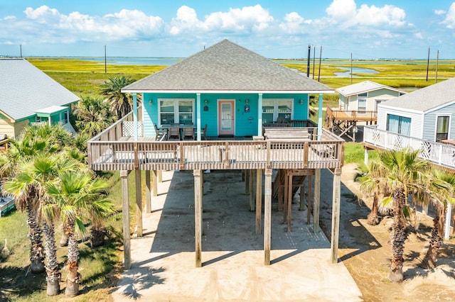 view of front facade featuring a wooden deck, a carport, and a porch