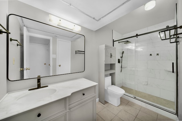 bathroom featuring vanity, a shower with door, toilet, and tile patterned floors