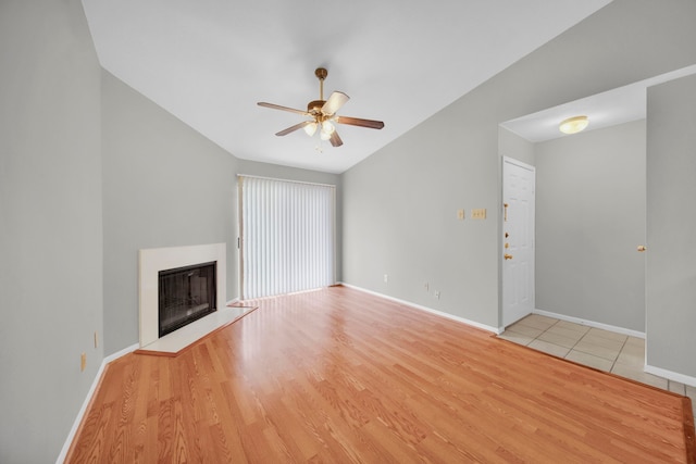 unfurnished living room featuring ceiling fan, vaulted ceiling, and light hardwood / wood-style flooring