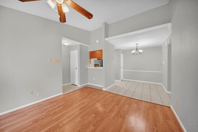 spare room with light hardwood / wood-style floors and ceiling fan with notable chandelier