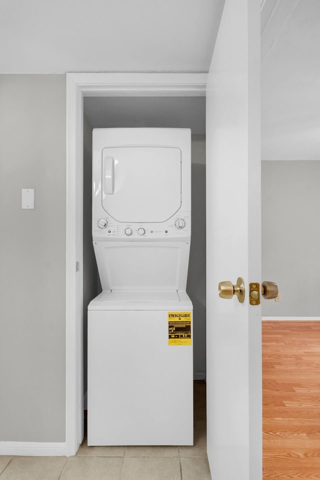 washroom with stacked washer / dryer and light hardwood / wood-style floors